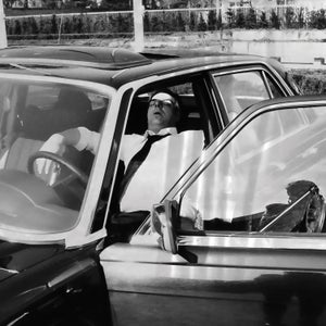 Vintage black and white photo of a man sleeping in a car