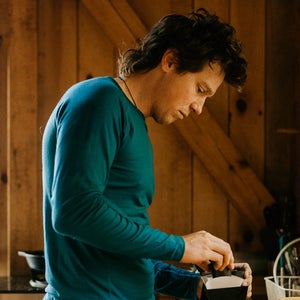 man making coffee wearing merino wool shirt