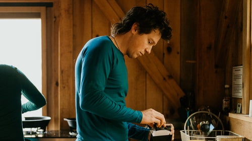 man making coffee wearing merino wool shirt