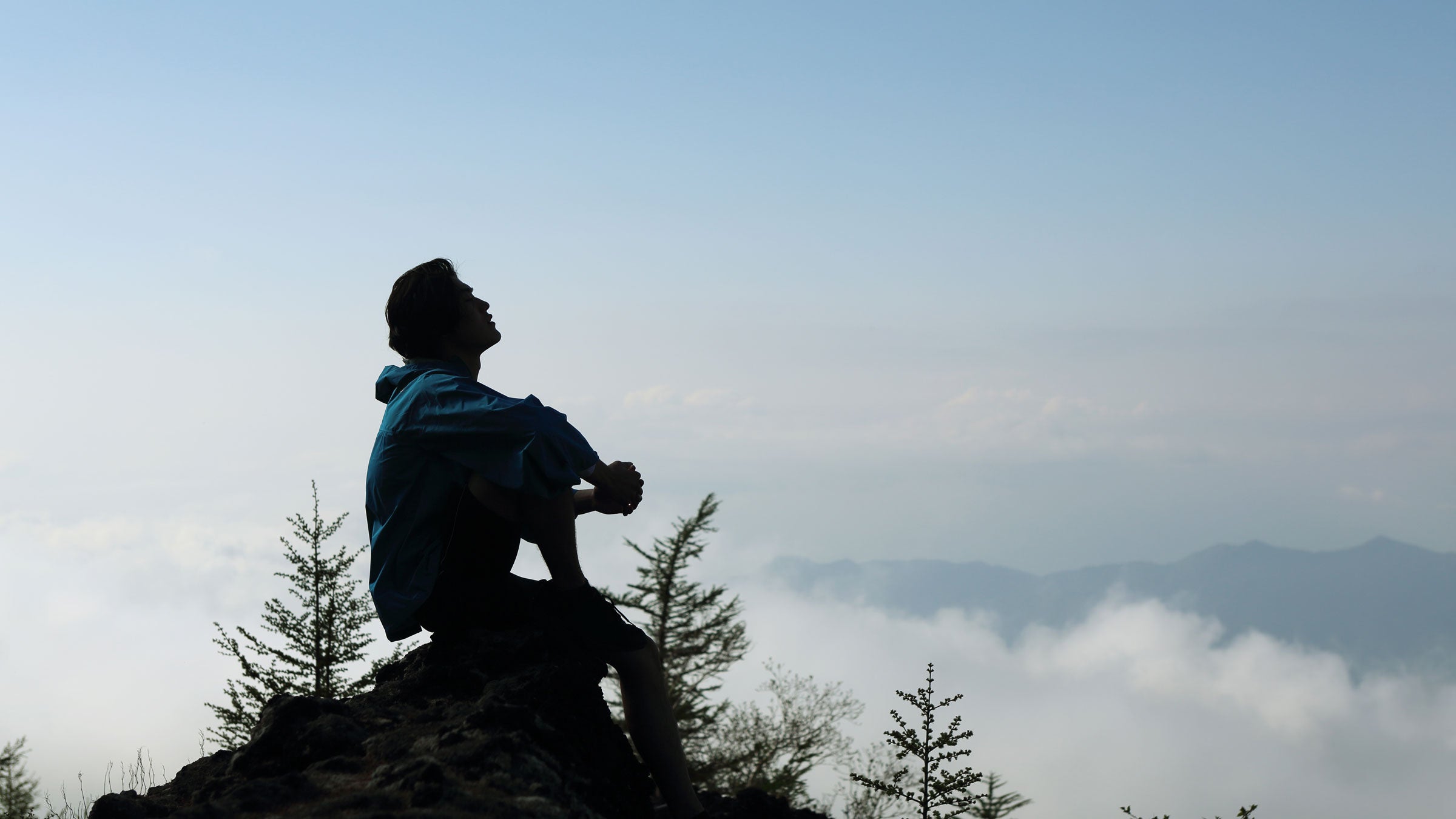 Man resting on top of a mountain after a panic attack