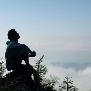 Man resting on top of a mountain after a panic attack