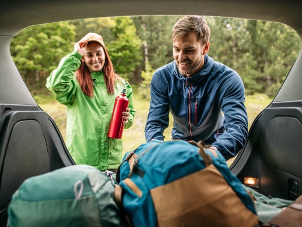 packing up camping equipment in the trunk of a car, ready for hiking