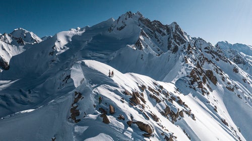 Skiers on a dramatic ridgeline