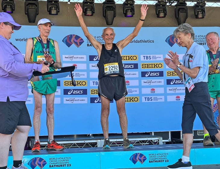 Roger Robinson raises his arms on the podium