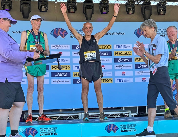 Roger Robinson raises his arms on the podium