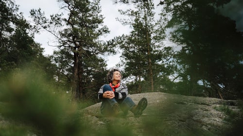 Hiker forest bathing on a rock