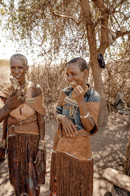 A pair of Datoga women look at themselves on a guide鈥檚 camera.
