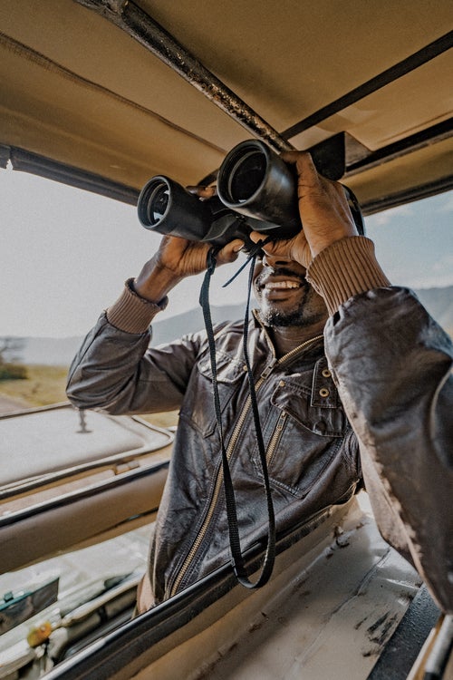 A guide scouts for wildlife in the crater.