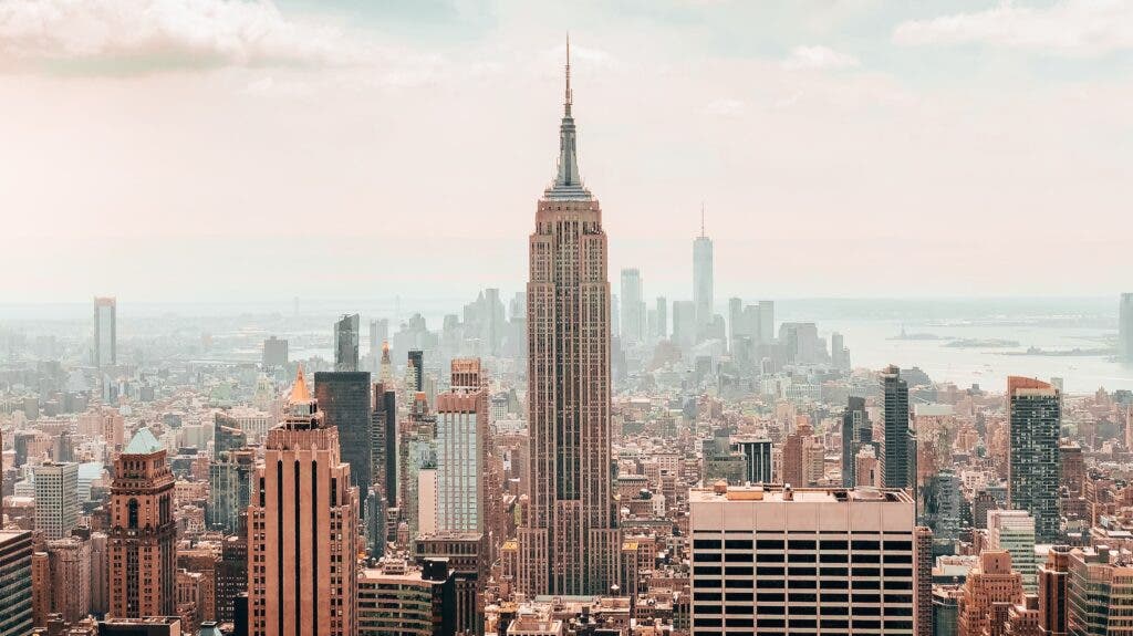 A photograph of the NYC skyline, with haze in the background and the Empire Building at center