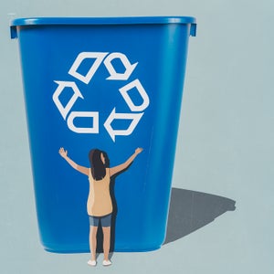 woman hugging a giant blue recycling bin with chasing arrows