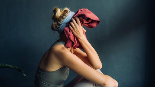 Woman wipes her face after difficult workout class