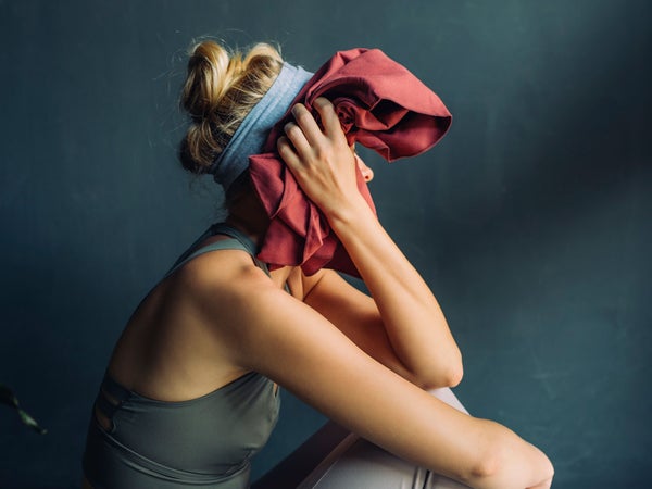 Woman wipes her face after difficult workout class