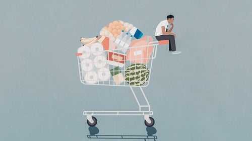 An illustration of a small person sitting atop a full grocery cart