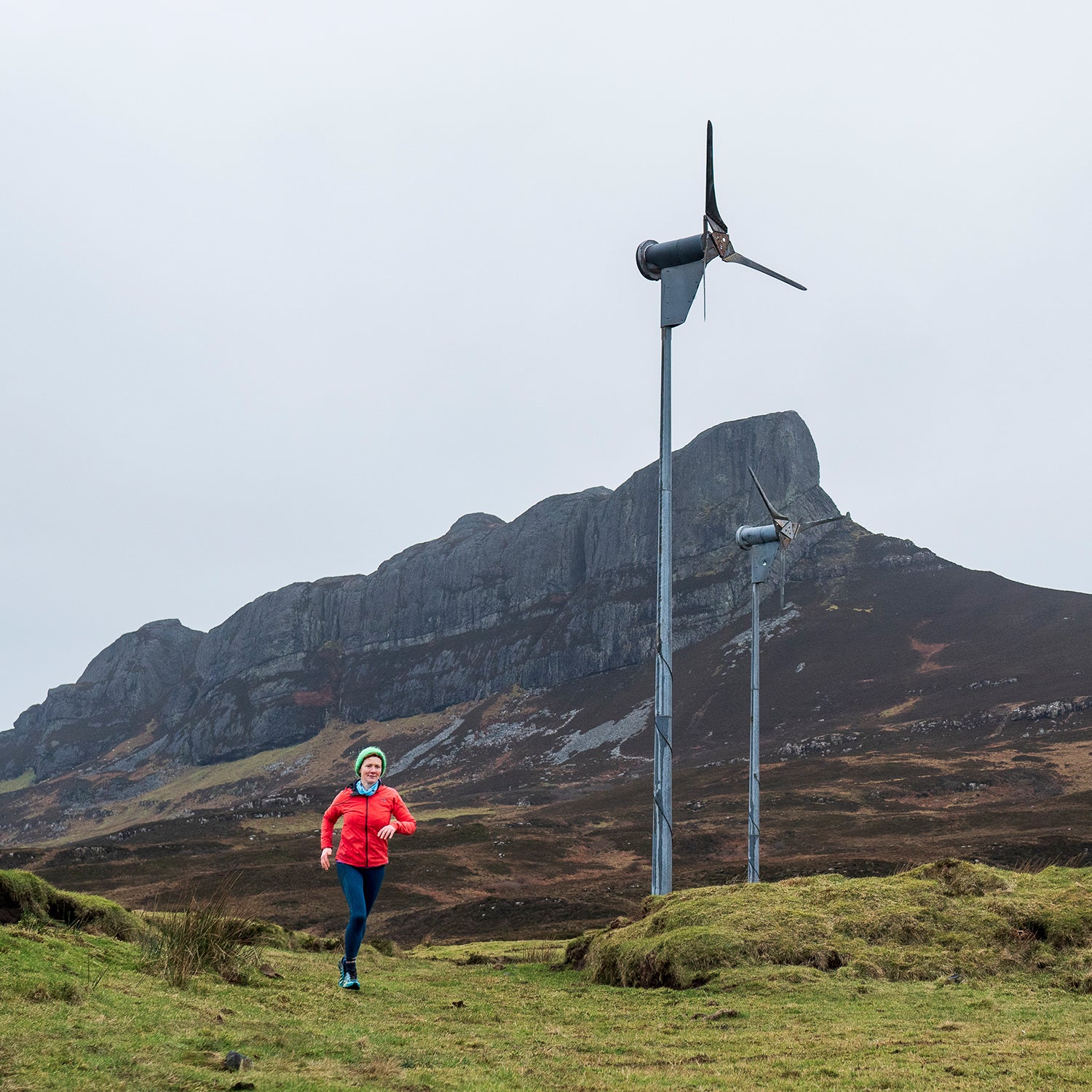 Sarah Boden, a trail runner and sheep farmer, runs in front of a wind turbine