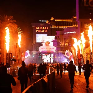 runners finish on the Las Vegas Strip at night, with flames and lights