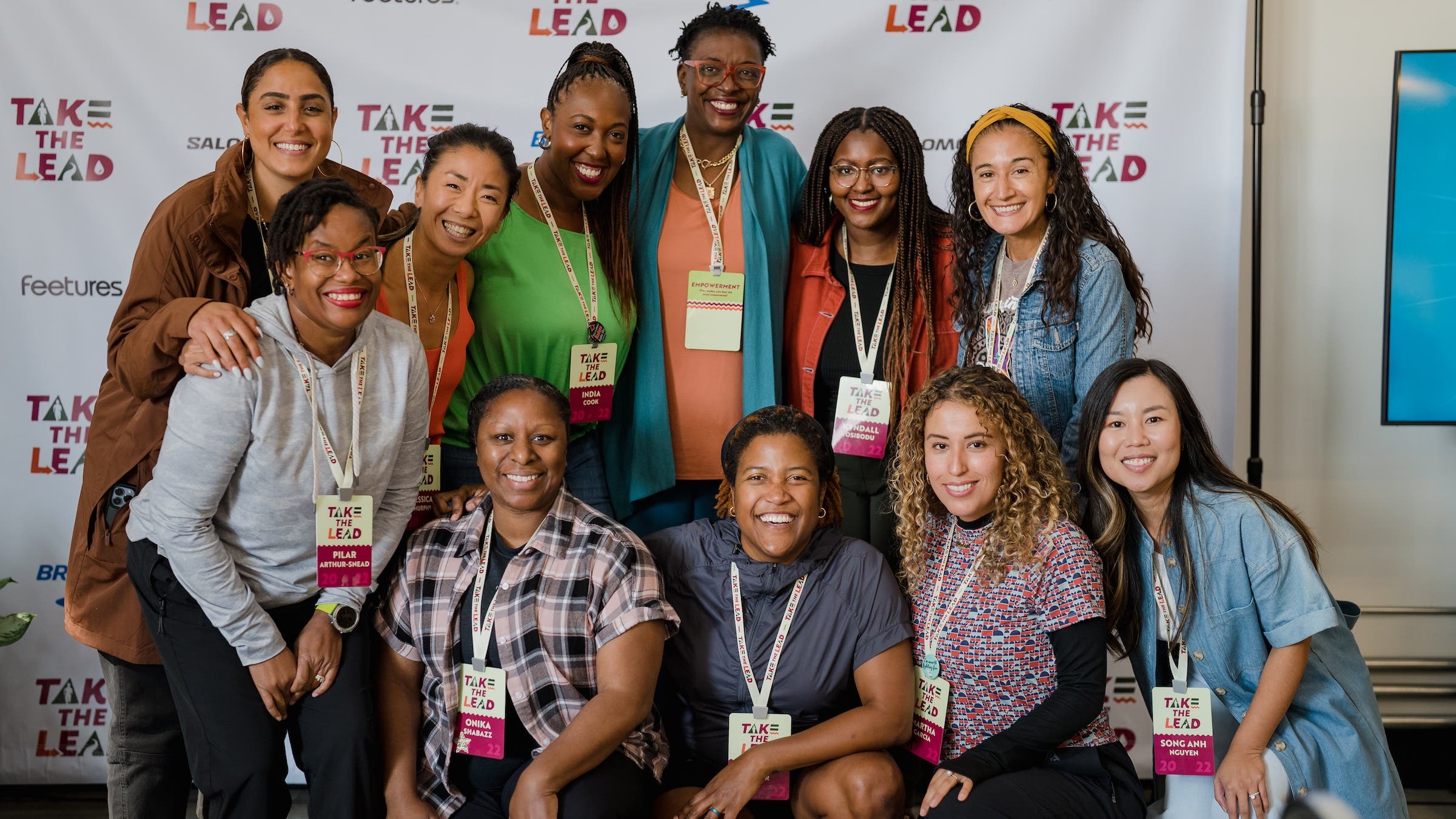 A group of several women standing and sitting at the WOC Take the Lead retreat