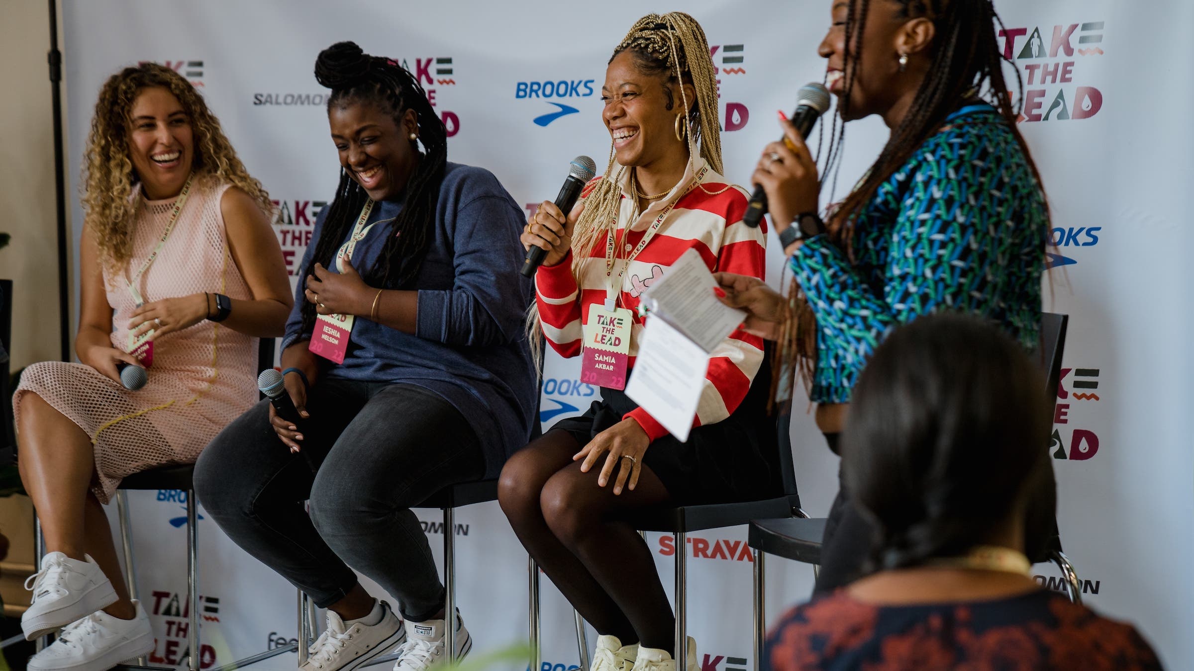 several women sit on stools for a panel at the WOC Take the Lead Retreat