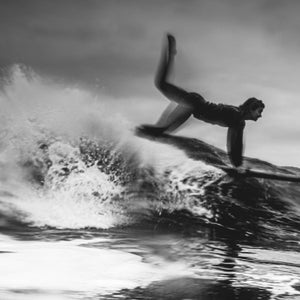 Black and white photo of a woman surfboarding