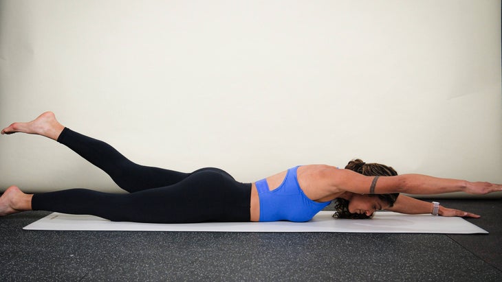 Woman demonstrates Alternating Supermans for a core workout