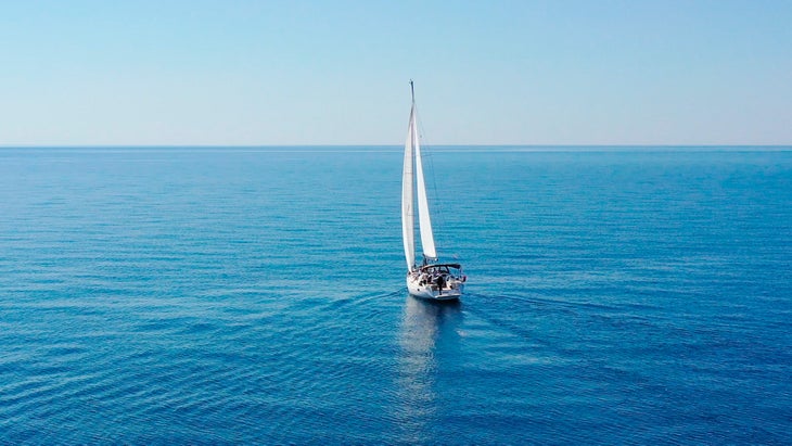 ship sailing into horizon during clear day