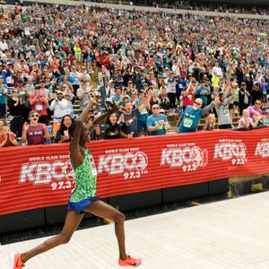 An elite finishes in the stadium in front of a large crowd