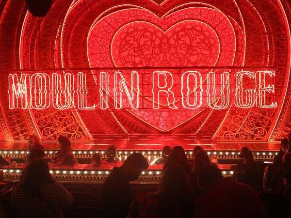 A dark red theater stage of Moulin Rouge