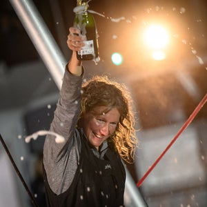 South African skipper Kirsten Neuschafer sprays champagne as she celebrates onboard her monohull Mannahaha after winning the around the world solo sailing race without any electronic assistance Golden Globe race, in Les Sables-d'Olonne coast, western France on April 27, 2023.