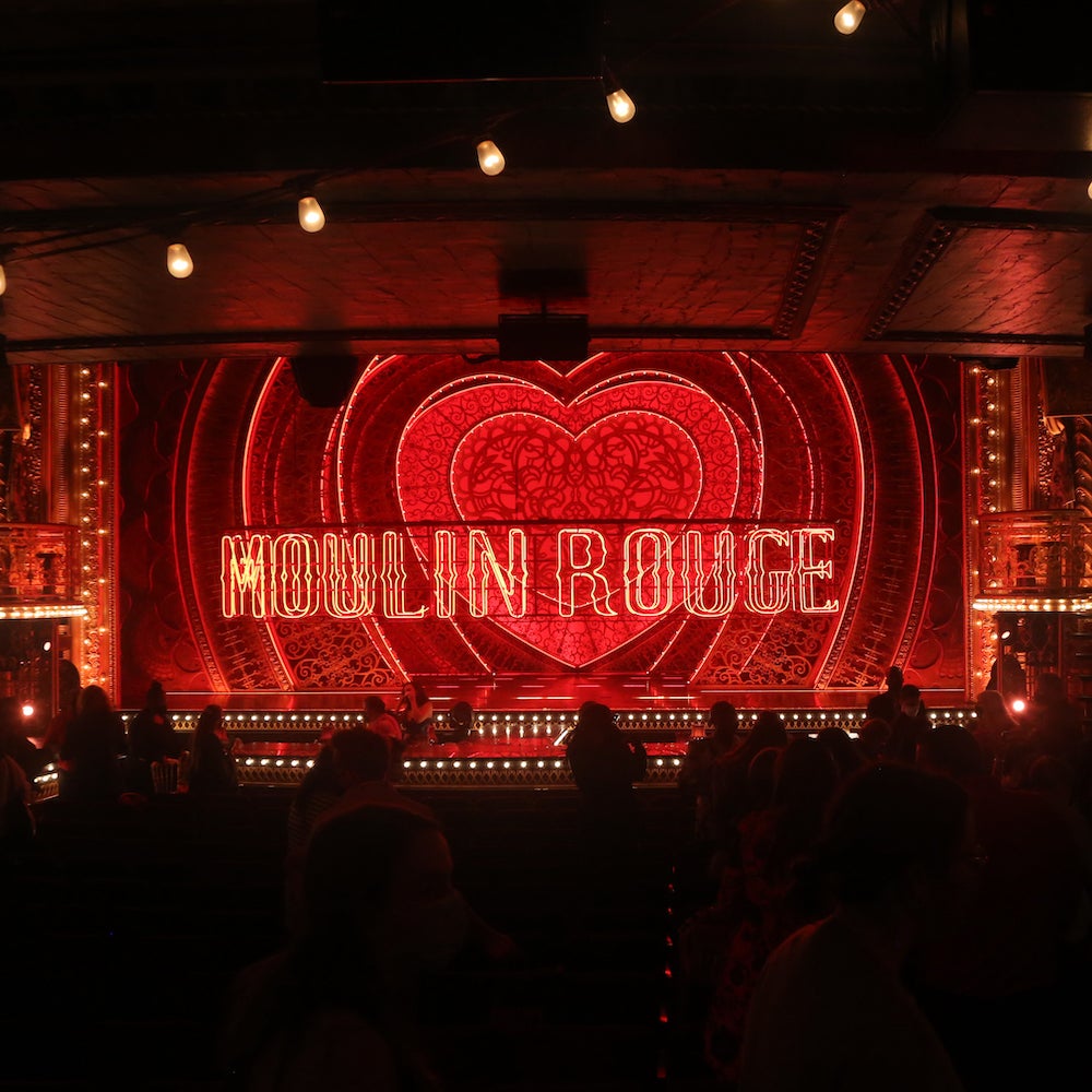 A dark red theater stage of Moulin Rouge