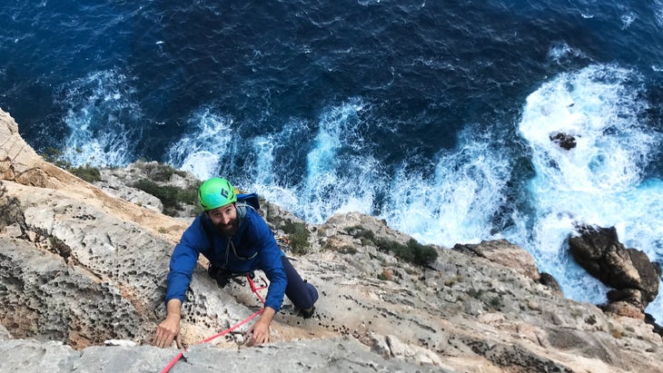 man climbing sea cliffs