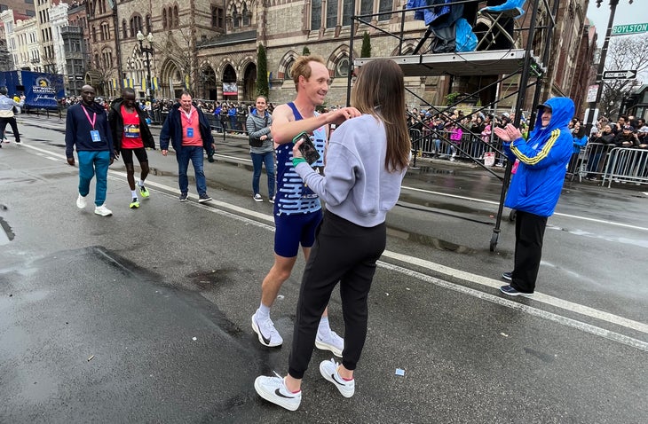 Scott Fauble hugs his partner after finishing the 2023 Boston Marathon