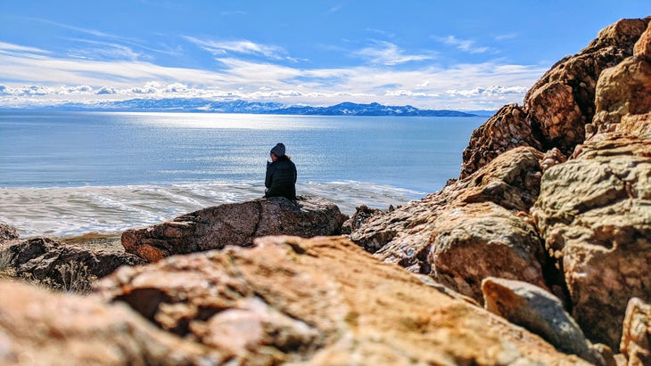 woman sitting on rock at Antelope Island State Park in Utah