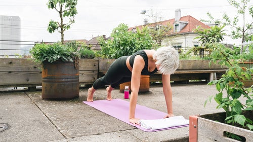 Woman practices a plank outside during a core workout