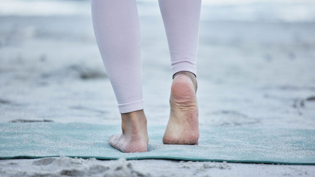 Foto de Female feet on the beach. Feet girl in yoga pant, pants