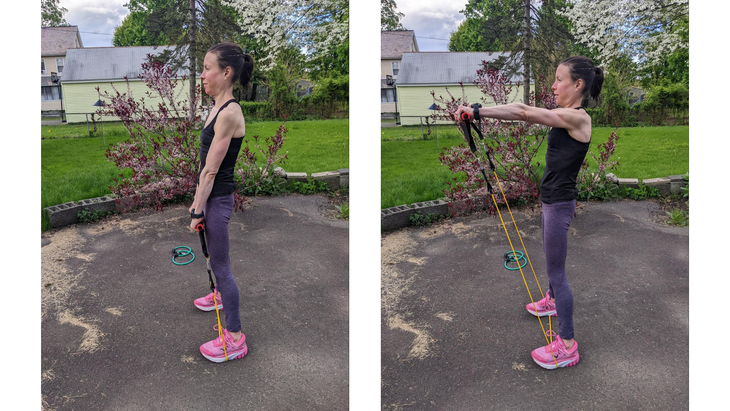 Woman demonstrates forward raises as part of a resistance band arm workout
