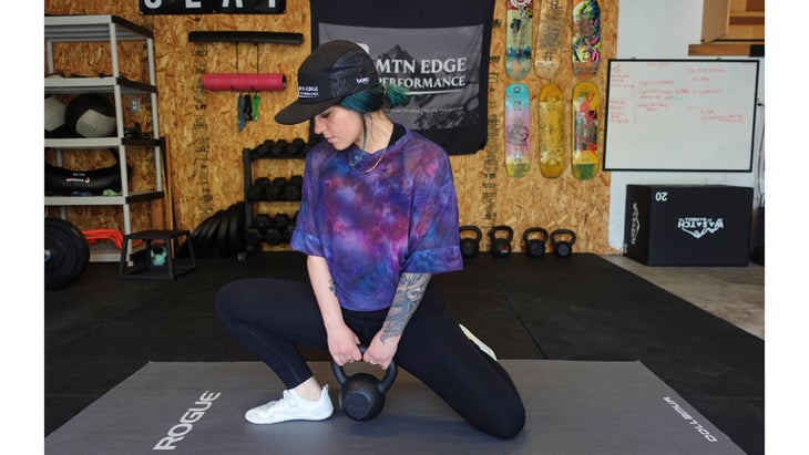 One of the mobility exercises for knee pain. A woman sits in a half kneeling position while leaning to the side of her bent knee.