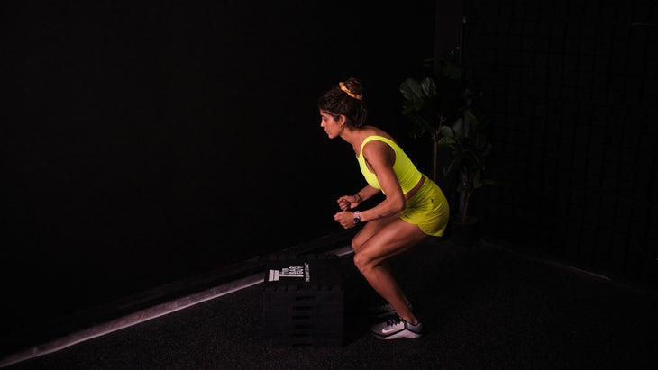 Woman practices a box jump as a hip hinge exercise
