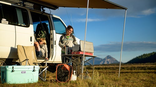 Cooking dinner next to a van in the wilderness