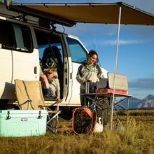 Cooking dinner next to a van in the wilderness