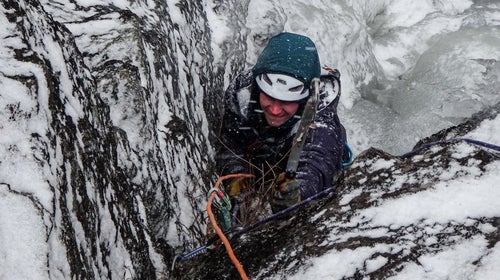 Climber in winter storm wearing a helmet