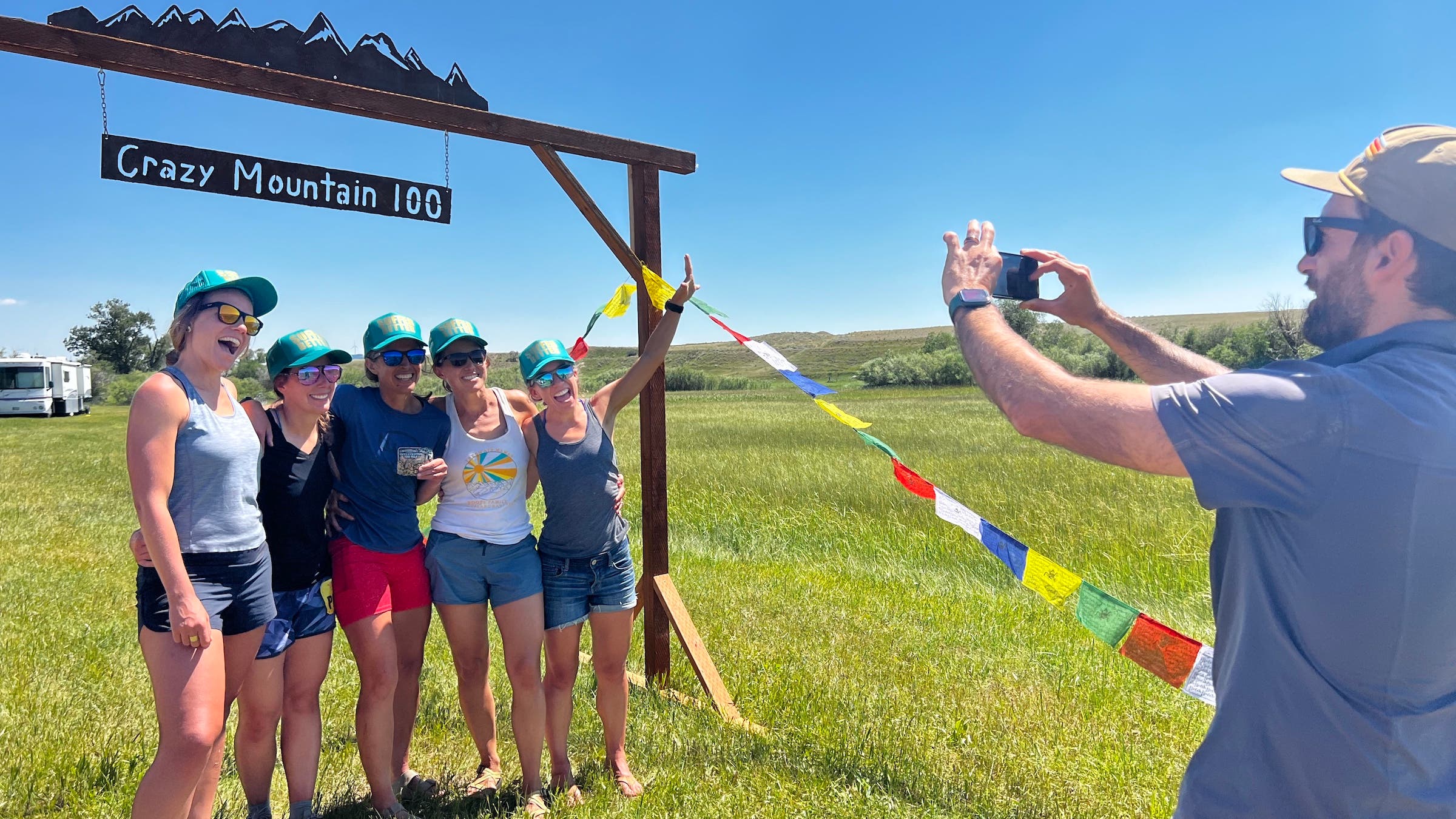 A bunch of women pose under the race finish banner