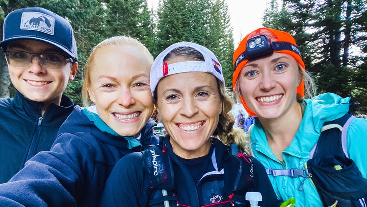Four women trail runners take a selfie in a Montana forest