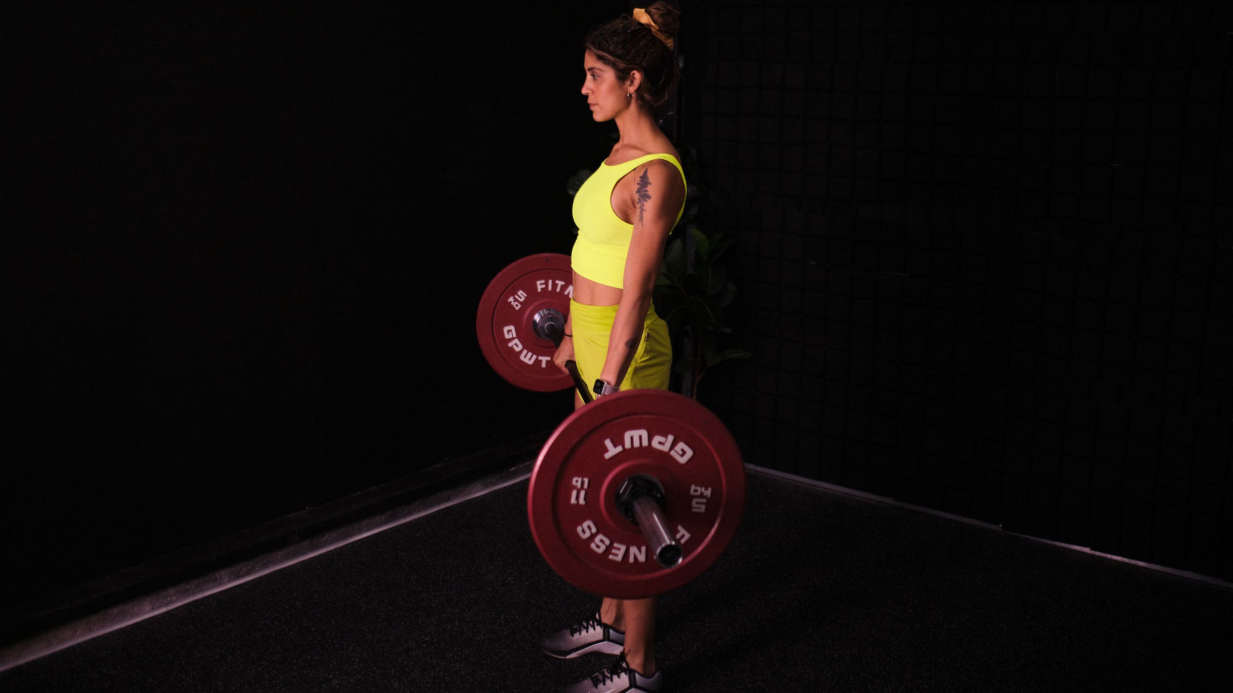 Woman demonstrates a deadlift as a hip hinge exercise