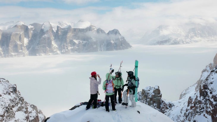 A wide shot of four women—Hilaree Nelson, Emily Harrington, Christina Lustenburger, and Brette Harrington—wearing skiing and climbing gear in a snowy landscape.