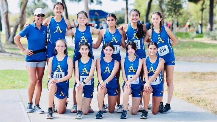 a cross-country team in blue take a team photo