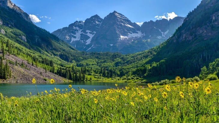 A summer view of Maroon Creek Valley, Colorado, with wildflowers and an alpine lake