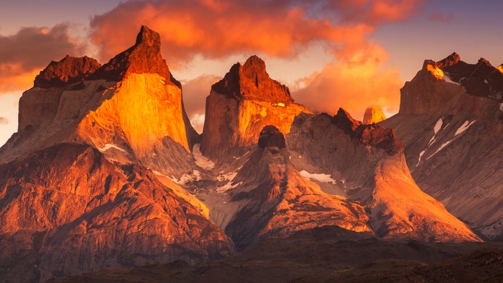 Torres del Paine National Park at dawn. Large mountains pink and orange.