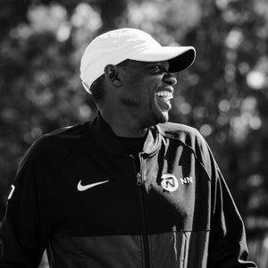 Patrick Sang laughing in a black and white frame