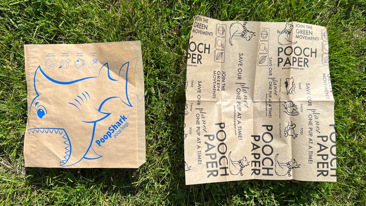 Two paper dog waste bags on grass