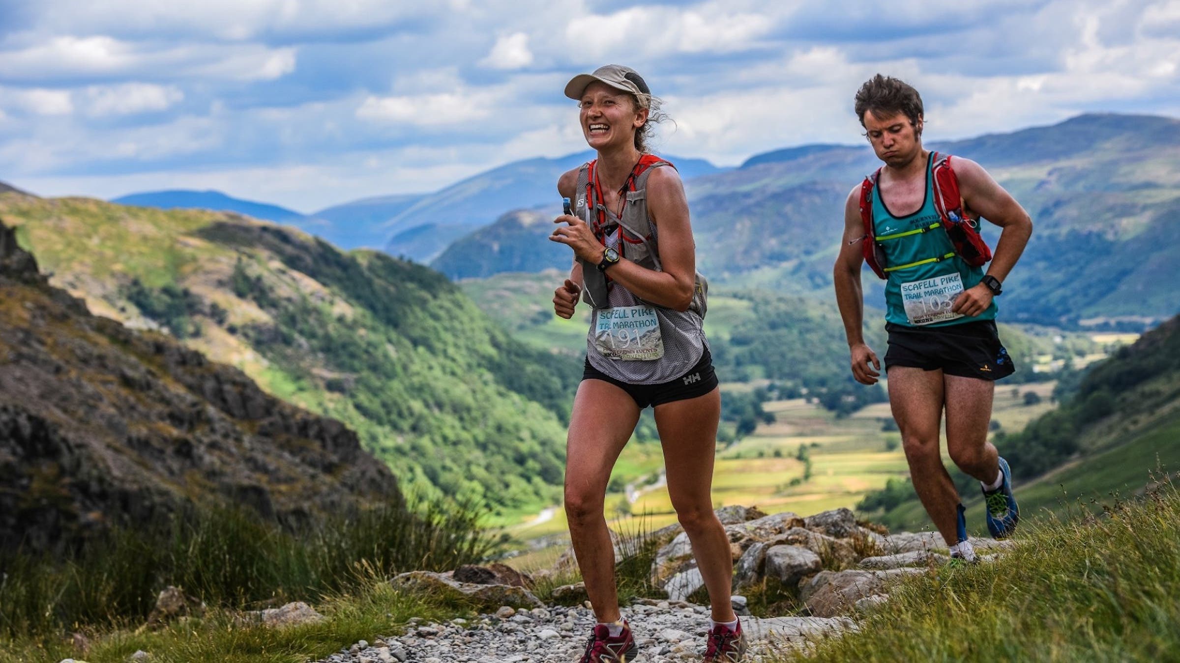 two runners on a trail smiling