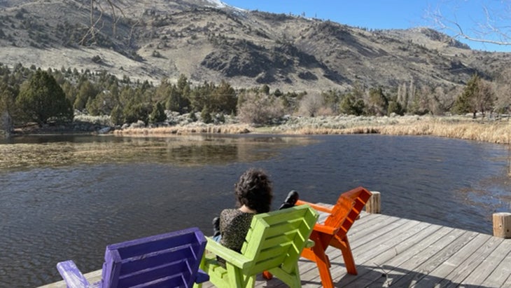 girl in chair looking at alpine lake